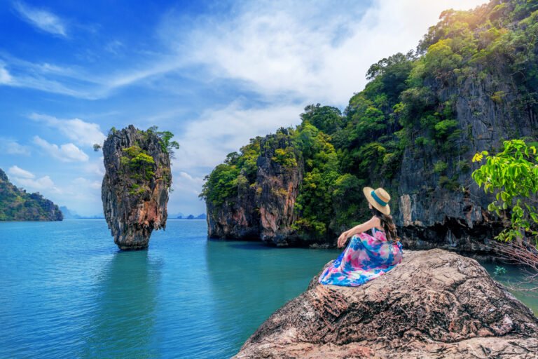Beautiful girl sitting on the rock at James Bond island in Phang
